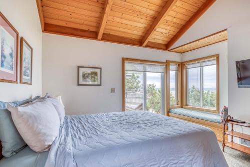 a bedroom with a large bed and windows at Sea Star #1 (MCA 51 A-GF) in Manzanita