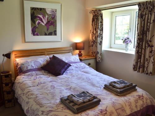a bedroom with a bed with two trays on it at Skyber Cottage in Lizard