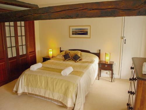 a bedroom with a large bed with two lamps on it at Elm Cottage in Beckermonds