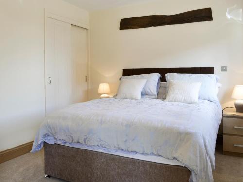 a bedroom with a large bed with white sheets and pillows at The Cartshed in Knaresborough