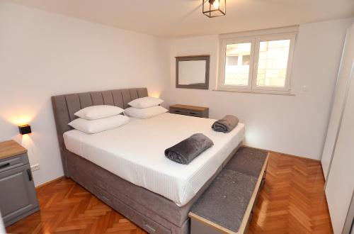 a bedroom with a large bed and a window at MY DALMATIA - M Apartment Trogir with free parking and roof terrace in Trogir