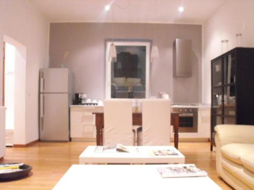 a living room with a refrigerator and a table and chairs at Il Casale Del Giglio in Santo Stefano di Magra