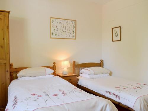 2 Einzelbetten in einem Zimmer mit weißen Wänden in der Unterkunft Whitegates in Portinscale