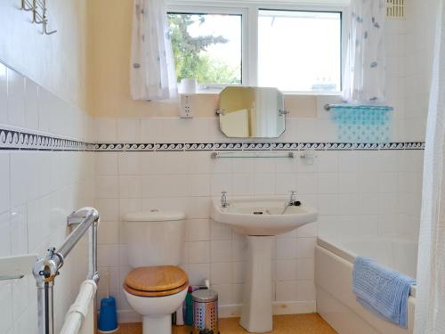 łazienka z umywalką, toaletą i oknem w obiekcie Whitegates w mieście Portinscale
