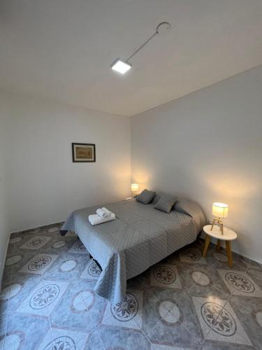 ljapartments Andrade 3 في Villa Marini: غرفة نوم بها سرير مع مصباحين