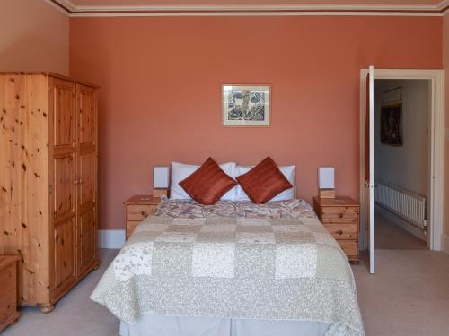 een slaapkamer met een groot bed en houten kasten bij Oakghyll in Windermere