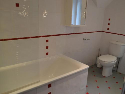 een witte badkamer met een bad en een toilet bij Oakghyll in Windermere