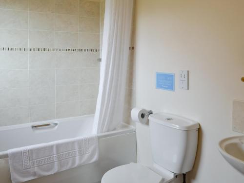a bathroom with a toilet and a shower and a sink at Kingfisher Cottage - 25114 in Flamborough