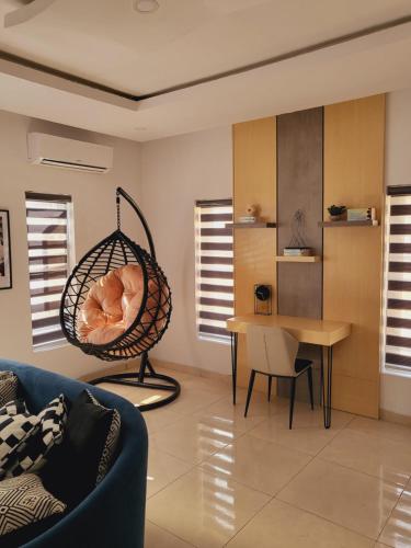 un soggiorno con altalena e tavolo di The Private Apartments: 2-Bedroom & 3-Bedroom a Port Harcourt