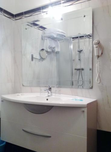 a bathroom with a sink and a shower with a mirror at Hotel Ai Sette Nani in Sistiana