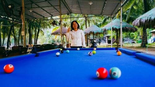 une femme debout devant un billard dans l'établissement Catba Beach House, à Cat Ba