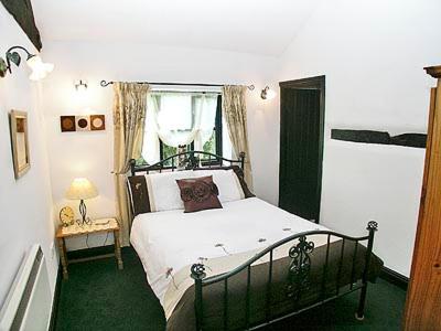 een slaapkamer met een bed en een raam bij Wagtail Barn in Yaxham