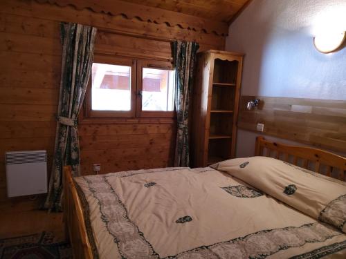 une chambre avec un lit dans une cabane en bois dans l'établissement Duplex confortable 3 pièces 6 pers avec balcon proche pistes et commerces à Méribel Village - FR-1-411-160, à Les Allues