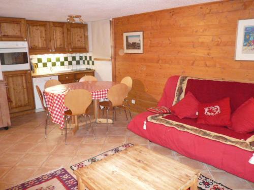 un salon avec un canapé rouge et une table dans l'établissement Duplex confortable 3 pièces 6 pers avec balcon proche pistes et commerces à Méribel Village - FR-1-411-160, à Les Allues