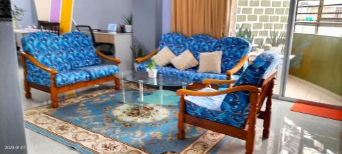 a living room with blue chairs and a glass table at Yuyu homestay in Johor Bahru