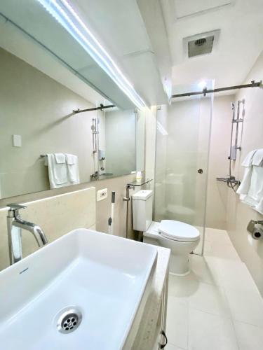 a bathroom with a white sink and a toilet at Amirah’s Place Azure North in San Fernando