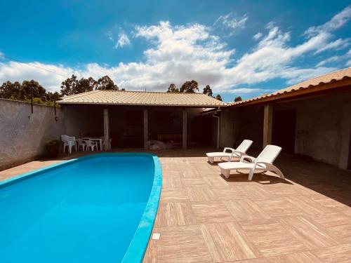 una piscina con 2 tumbonas junto a una casa en Rest house, en Laguna