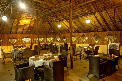 un ristorante con tavoli e sedie in una stanza di Farm Stay Resort - Shamirpet, Hyderabad a Hyderabad