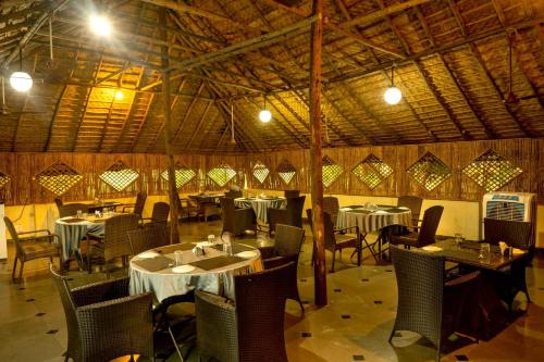 a restaurant with tables and chairs in a room at Farm Stay Resort - Shamirpet, Hyderabad in Hyderabad