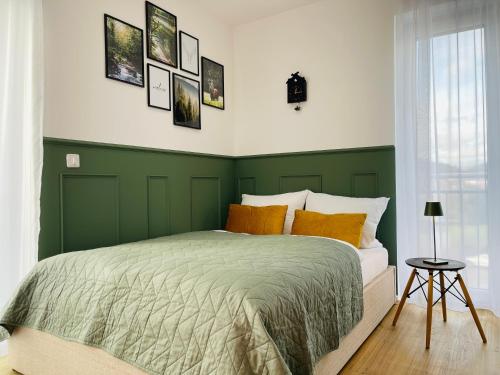 Habitación verde y blanca con cama con almohadas de color naranja en Stay zentrale Schwarzwald Apartments, en Nagold