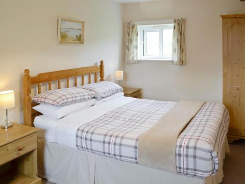 a bedroom with a bed and a window at Foxglove Cottage in Wootton Fitzpaine