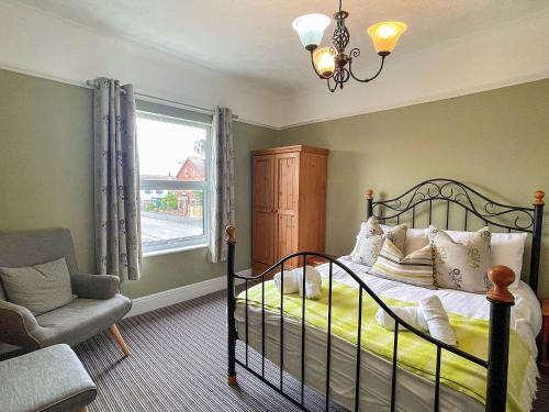 a bedroom with a bed and a chair and a window at Twenty in Sutton on Sea