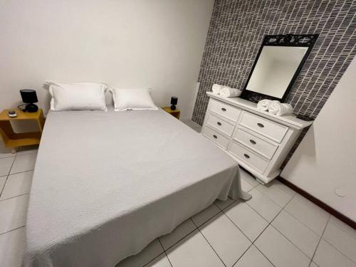 um quarto com uma cama com um espelho e uma cómoda em Appartement vu Mer & Piscine em Le Gosier
