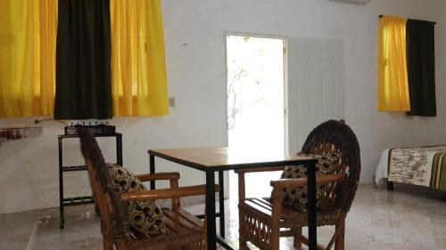 uma sala de jantar com uma mesa e duas cadeiras em Casas y departamentos em Oxkutzcab
