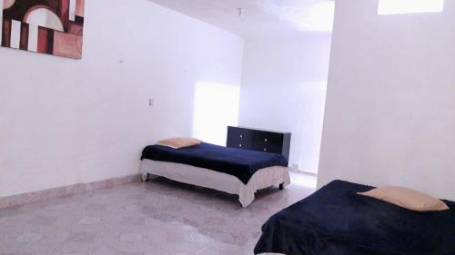 um quarto com duas camas num quarto em Casas y departamentos em Oxkutzcab