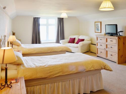 a bedroom with two beds and a couch at Court Place in Porlock