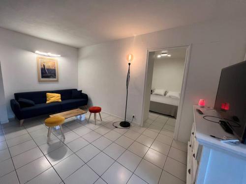 uma sala de estar com um sofá azul e uma mesa em Appartement vu Mer & Piscine em Le Gosier