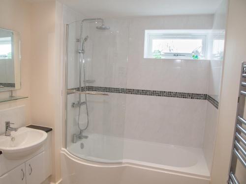 baño blanco con ducha y lavamanos en Apartment 11 - Latitude 51, en Westward Ho