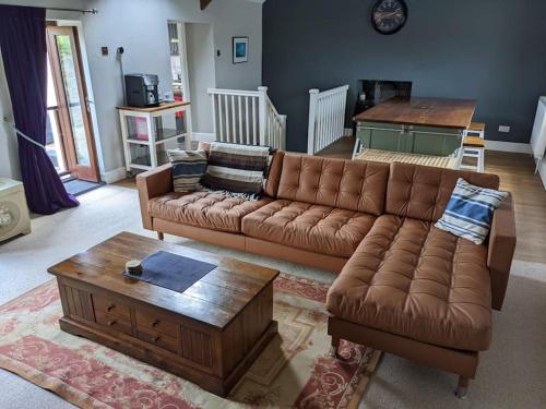 a living room with a couch and a coffee table at Yellow Welsh Cottage-Coastal Retreat Village View in Bridgend