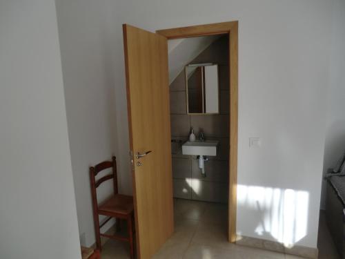 een badkamer met een deur naar een wastafel bij Flor de Lis in Benasal