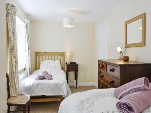 a bedroom with two beds and a dresser at Ty Newydd Y Graig - 28017 in Tremeirchion