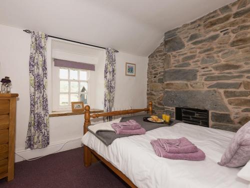 a bedroom with a bed with two towels on it at Under Moor Cottage in Blaenau-Ffestiniog