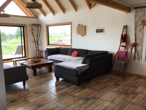 ein Wohnzimmer mit einem Sofa und einem Tisch in der Unterkunft Bello Horizonte Lodge in Villarrica