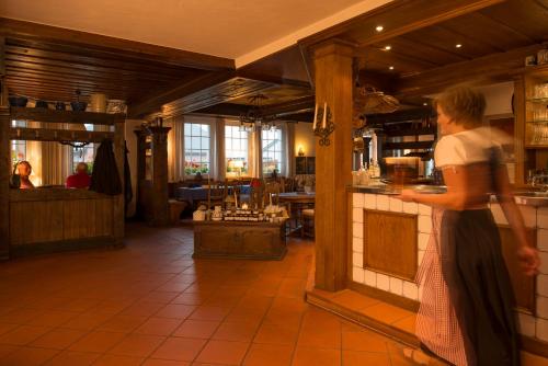 Uma mulher está num balcão num restaurante. em Hotel Waldhaus Föckinghausen em Bestwig