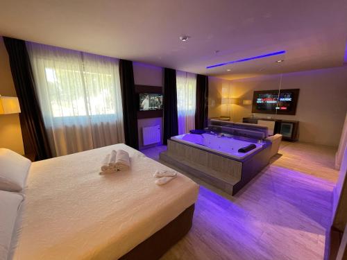 Felix Hotel في فالس: غرفة في الفندق مع حوض استحمام وسرير