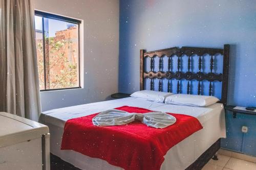 a bedroom with a bed with a red blanket at Diamantina Palace Hotel in Morro do Chapéu