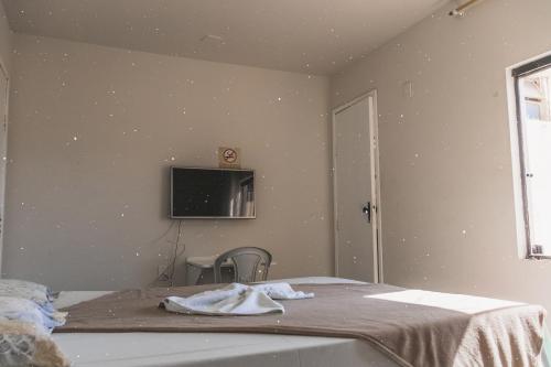 um quarto com uma cama e uma televisão na parede em Diamantina Palace Hotel em Morro do Chapéu
