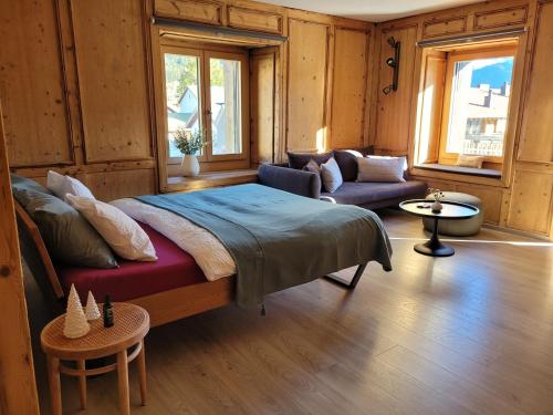 a bedroom with a large bed and a couch at Ferienwohnung PARDI in Lenz