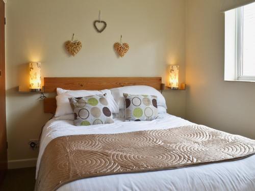 CoteにあるBeech Cottageのベッドルーム1室(白いベッド1台、枕、照明2つ付)