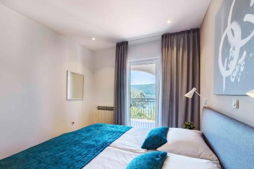 a bedroom with a bed and a large window at Apartment Rabac 12 in Rabac