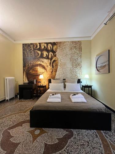 a bedroom with a large bed with two towels on it at Domus La Foce Hotel self check in in Genova