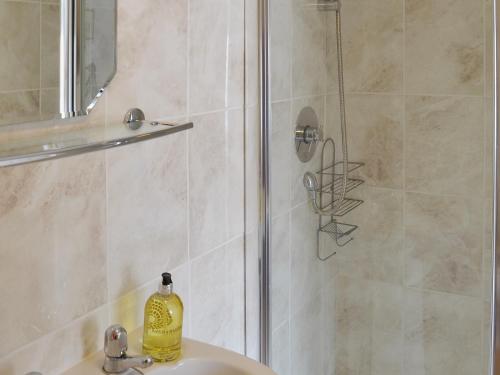 une douche avec une bouteille de savon sur un lavabo dans l'établissement Upper Floors At The Lawns, à Filey