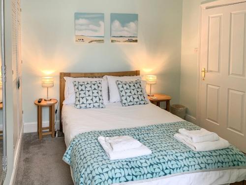 a bedroom with a bed with two towels on it at Upper Floors At The Lawns in Filey