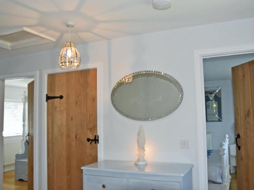 a room with a mirror on the wall and a dresser at Woodbrook Cottage in Bridport