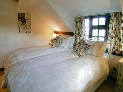 a bedroom with a large white bed with a window at Starboard Cottage in Winterton-on-Sea