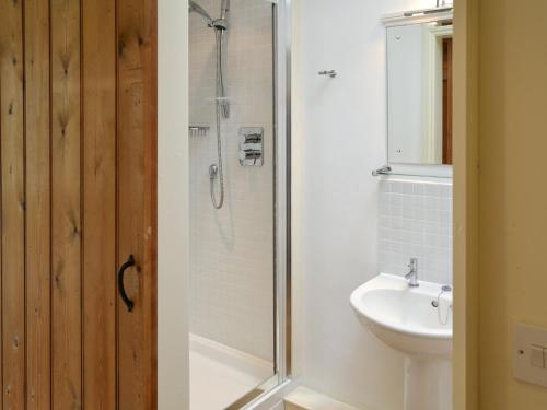 La salle de bains est pourvue d'une douche et d'un lavabo. dans l'établissement The Stables, à Occold
